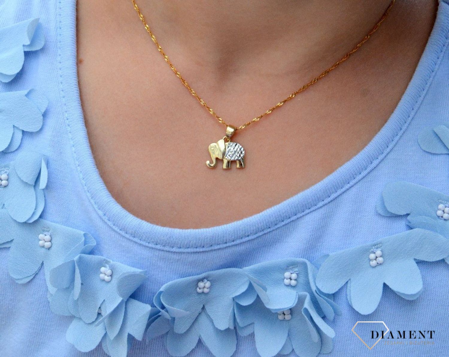 Złota zawieszka 333 słoń z białym złotem ZA 6873 333. Piękno zawarte w subtelnym detalu, w postaci zawieszki o kształcie słonia. Utrzymana w najnowszych trendach złota biżuteria inspirowana motywem amuletów, to oryginalny do.jpg